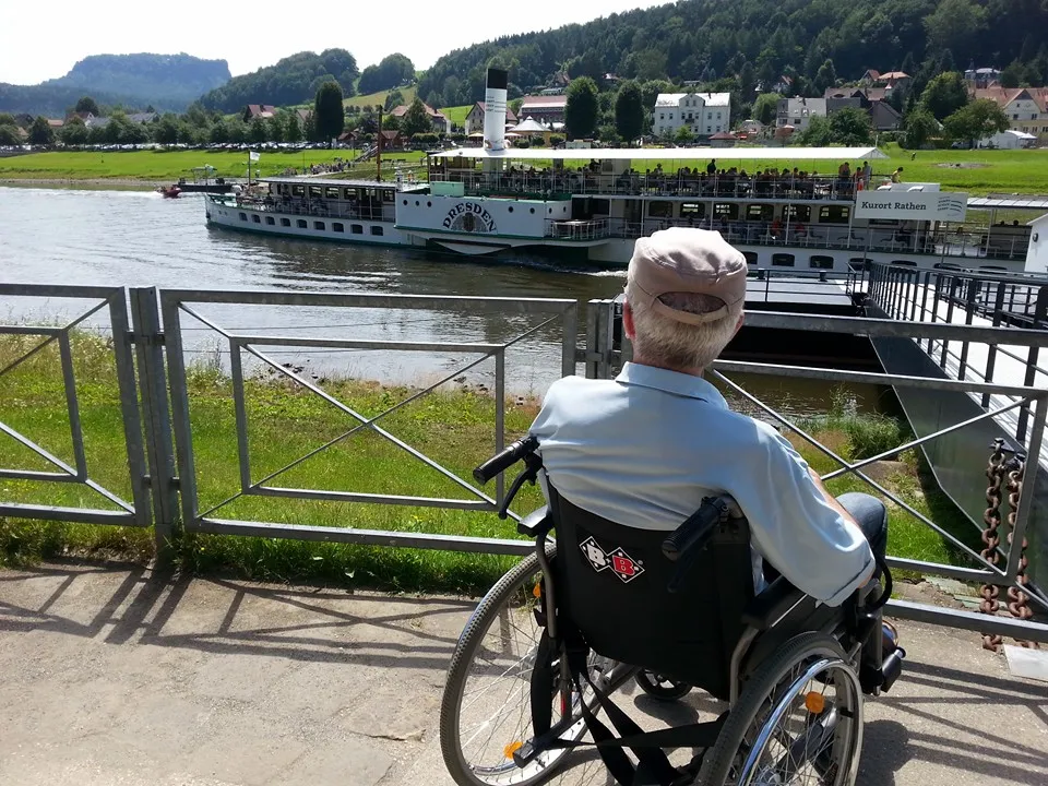 Mann im Rollstuhl der auf einen Fluss schaut
